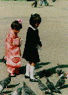 Girls feeding pigeons