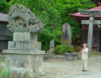 古殿八幡神社の狛犬を見上げる大塚康生さん