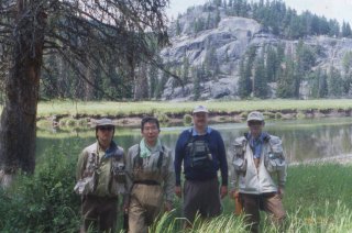 Four flyfishers on the bank of Slough Creek