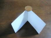 折った紙の角に１０円玉